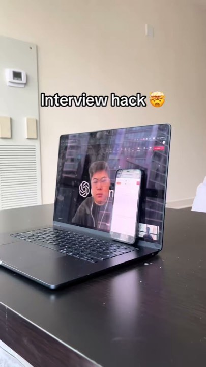 Laptop video interview with a phone placed in front